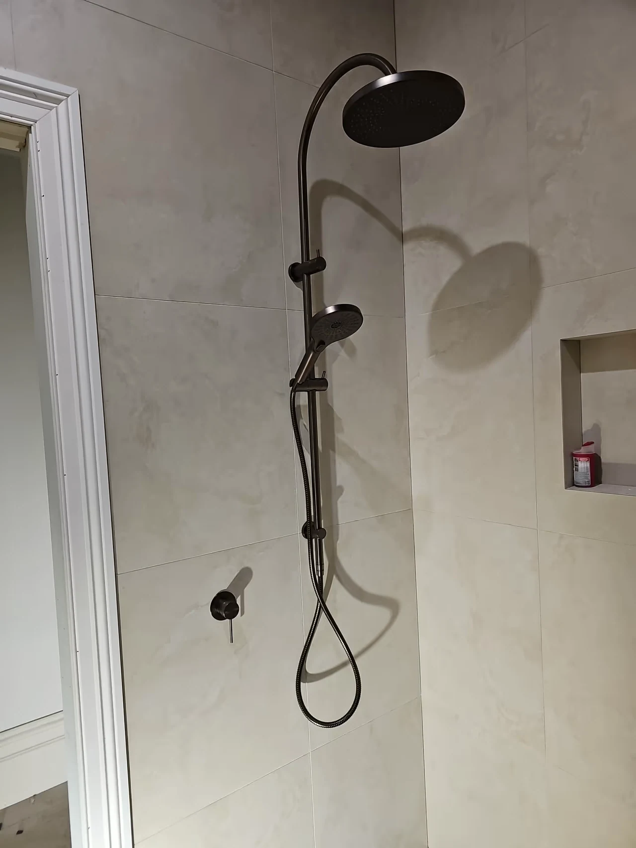 Dark shower fittings against tiled walls on a Flow-Rite job
